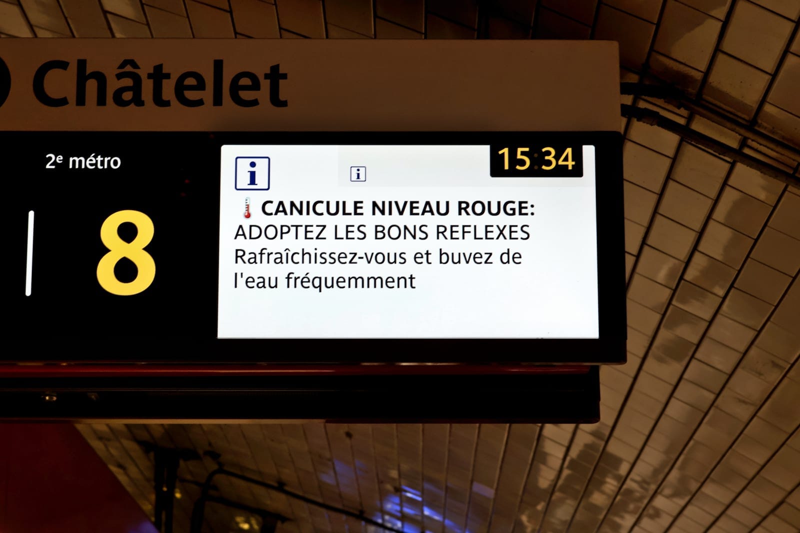 Écran d'information de la station de métro Châtelet, à Paris, affichant un message « Canicule niveau rouge : adoptez les bons réflexes »