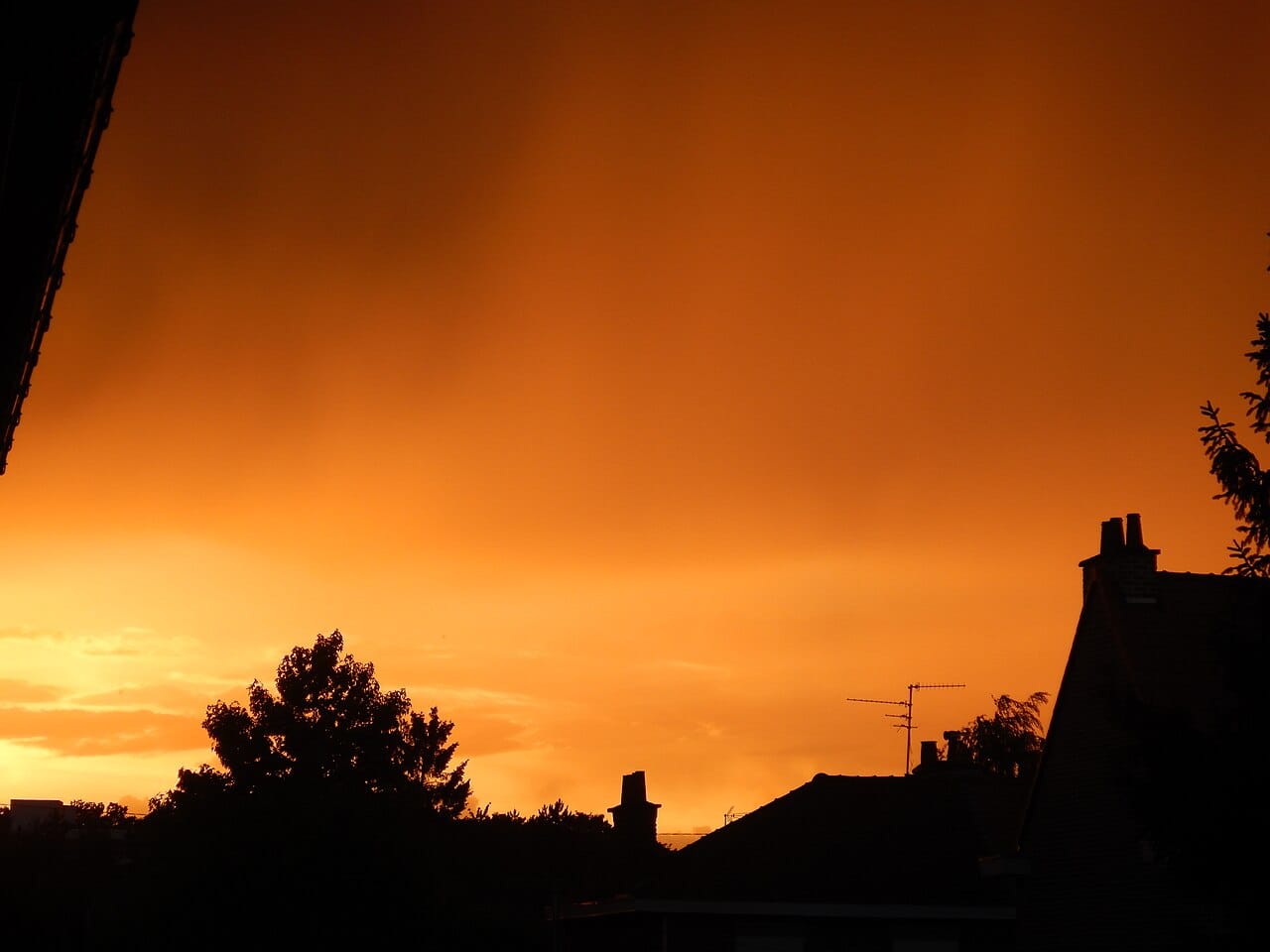 Ciel orangé chargé de nuages d'orage au-dessus de toits lillois, au soir du 19 juin 2026, pendant la première vague de chaleur de l'été