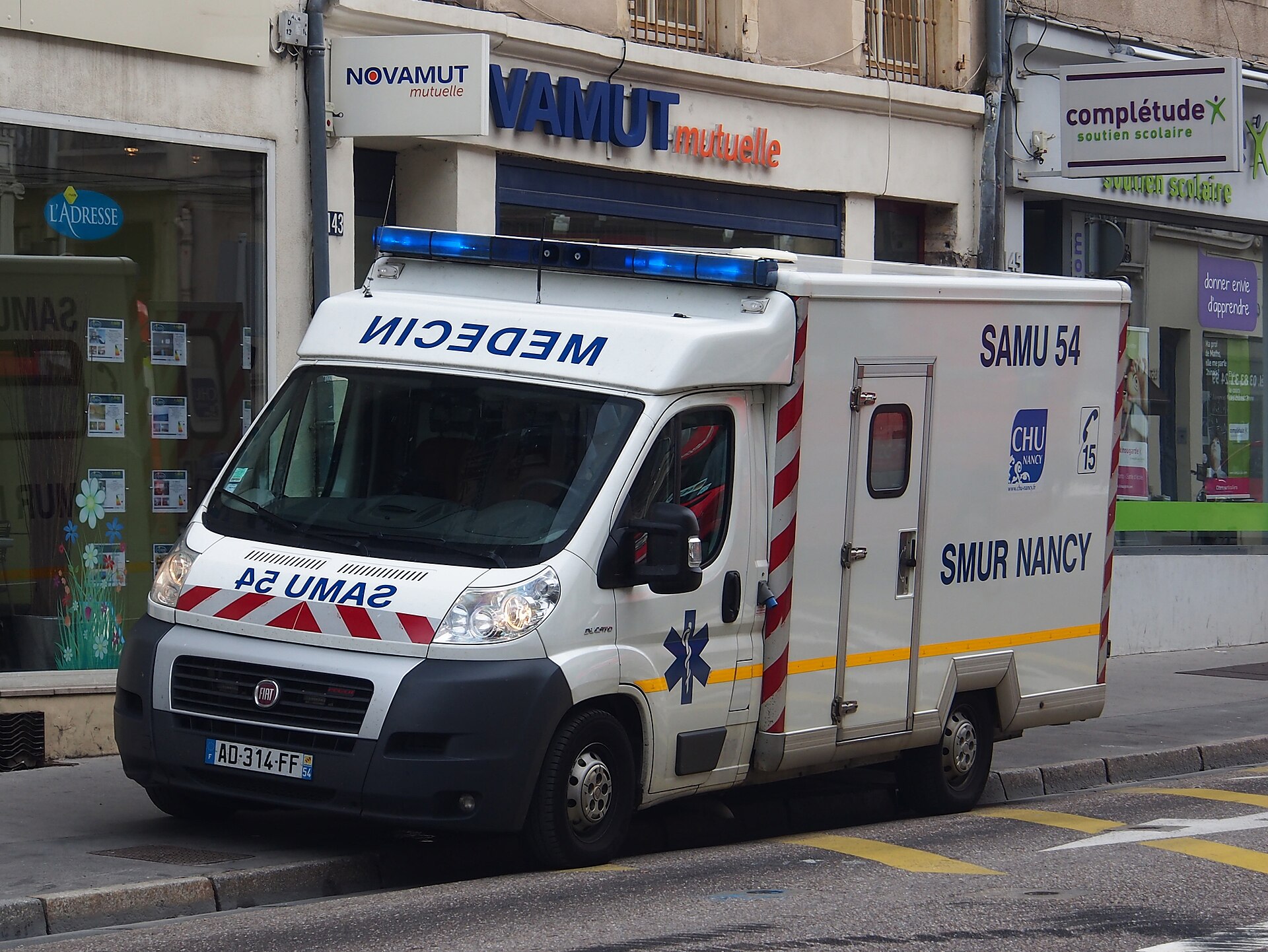 Ambulance de réanimation du SAMU stationnée dans une rue, gyrophares bleus allumés