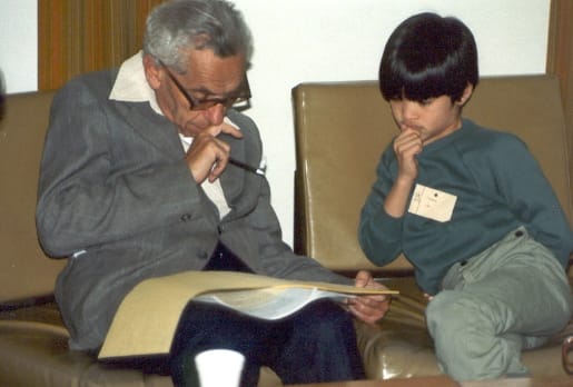 Paul Erdős, âgé, en conversation avec un jeune Terence Tao attablé