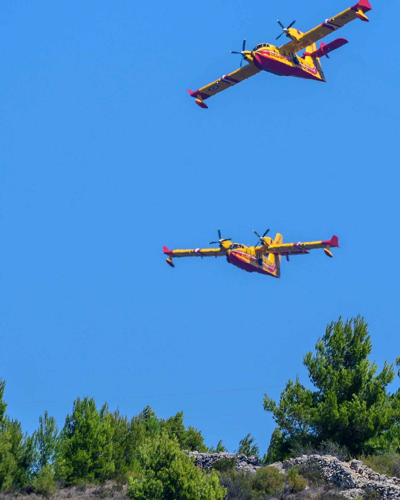 Deux bombardiers d'eau larguent leur charge au-dessus d'un feu de forêt en France