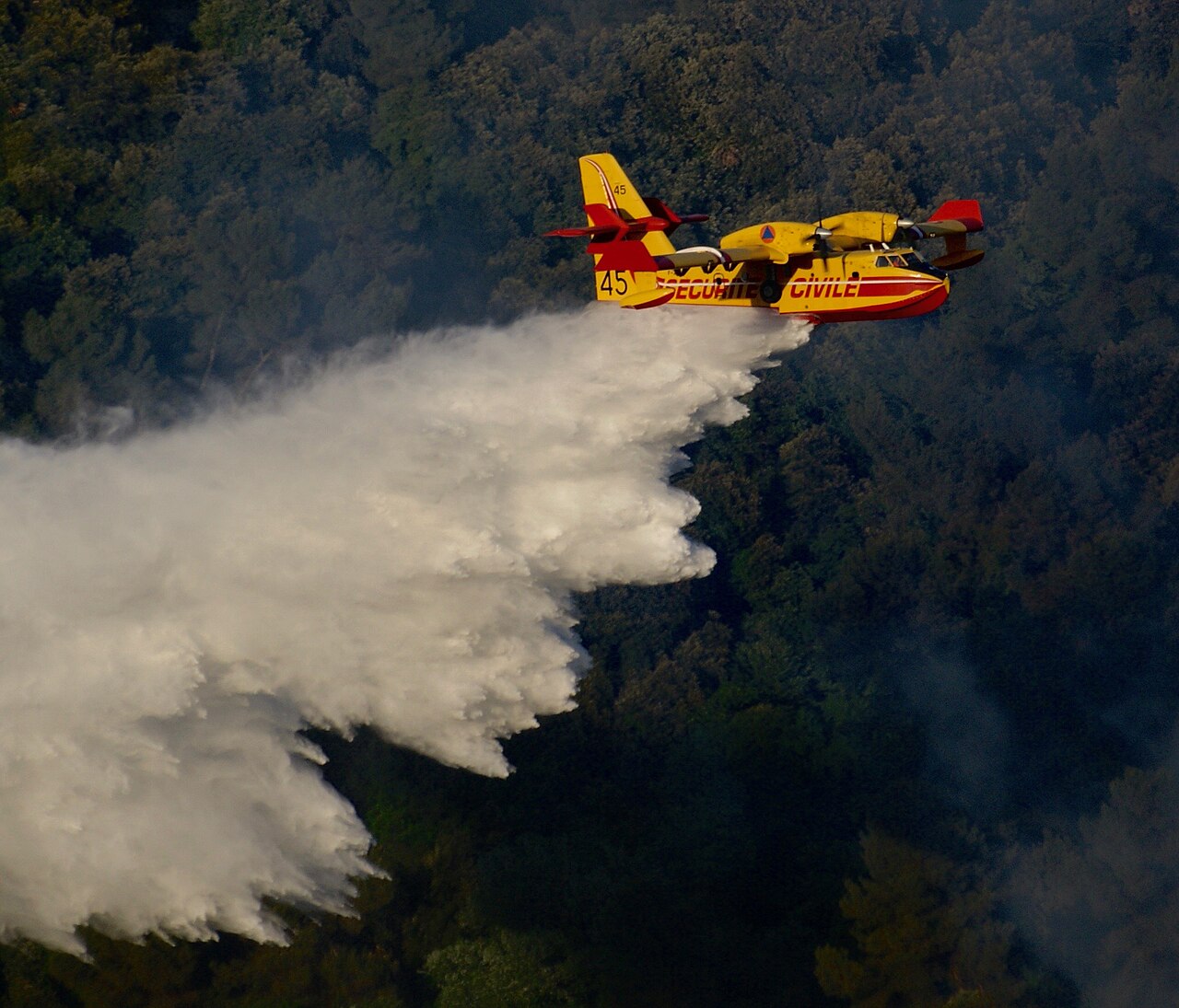 Canadair CL-415 de la Sécurité civile larguant de l'eau sur un feu de forêt