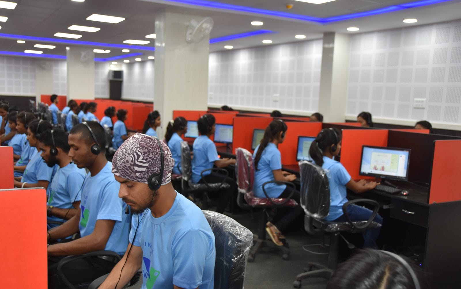 Rangées de personnes travaillant sur ordinateur dans un centre d'externalisation numérique en Inde.